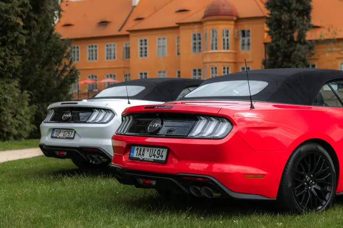 Zadní pohled na červený a bílý Ford Mustang GT Cabrio